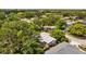 An aerial view of a home with a screened pool, surrounded by mature trees and other homes in the neighborhood at 1905 Oro Ct, Clearwater, FL 33764