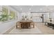 Bright dining area featuring a large wood table, modern chairs, and a view into the kitchen at 1905 Oro Ct, Clearwater, FL 33764