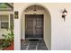 Inviting entryway with double doors, stone flooring, and decorative sconce lighting at 1905 Oro Ct, Clearwater, FL 33764