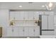 Bright kitchen featuring sleek white cabinetry, modern appliances, marble backsplash, and stylish gold hardware at 1905 Oro Ct, Clearwater, FL 33764