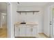 Functional laundry area with modern cabinetry, sink, shelving, and stylish wood-look flooring at 1905 Oro Ct, Clearwater, FL 33764