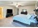Bedroom features a large bed, mounted TV, ceiling fan, and dark wood furniture at 19278 Roseate Dr, Lutz, FL 33558