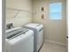 Functional laundry room features modern washer and dryer with convenient shelving at 19278 Roseate Dr, Lutz, FL 33558