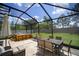 Screened-in patio with hot tub, outdoor seating and dining area, offering a relaxing outdoor experience at 19278 Roseate Dr, Lutz, FL 33558