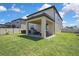 Spacious backyard featuring a covered patio, lush green grass, and privacy fencing perfect for outdoor enjoyment at 19796 Long Lake Ranch Blvd, Lutz, FL 33558