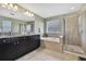 Luxurious bathroom with granite counters, dual sinks, glass shower, and soaking tub at 19796 Long Lake Ranch Blvd, Lutz, FL 33558