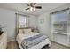 Bright bedroom featuring wood look floors, neutral walls, ceiling fan, and large windows at 19796 Long Lake Ranch Blvd, Lutz, FL 33558