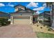 Charming two-story home with a brick driveway, well-manicured landscaping, and a welcoming front entrance at 19796 Long Lake Ranch Blvd, Lutz, FL 33558