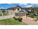 Stunning two-story home with a brick driveway, manicured lawn, and mature trees offering a picturesque setting at 19796 Long Lake Ranch Blvd, Lutz, FL 33558