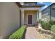 Close-up of the front door featuring potted plants, and brick walkway at 19796 Long Lake Ranch Blvd, Lutz, FL 33558