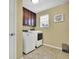 Functional laundry room with washer, dryer, overhead cabinets and novelty wall decor at 19796 Long Lake Ranch Blvd, Lutz, FL 33558