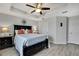 Stylish main bedroom featuring a tray ceiling, modern decor, and wood-look flooring at 19796 Long Lake Ranch Blvd, Lutz, FL 33558