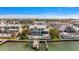 Waterfront home featuring lush landscaping, a circular driveway, a pool and a boat dock at 213 Harrison Ave, Belleair Beach, FL 33786