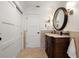 Bathroom with dark wood vanity, decorative mirror and sconces, and white sliding doors at 213 Harrison Ave, Belleair Beach, FL 33786
