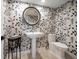 Elegant half bath with custom wall coverings, a pedestal sink, and classic fixtures at 213 Harrison Ave, Belleair Beach, FL 33786