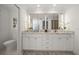 Modern bathroom with dual sinks, marble countertop, elegant vanity, and a decorative geometric patterned rug at 213 Harrison Ave, Belleair Beach, FL 33786