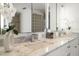 Bathroom showcasing a marble countertop with dual sinks and stylish faucet fixtures with decorative orchid at 213 Harrison Ave, Belleair Beach, FL 33786