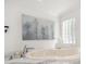 Bright bathroom showcasing a luxurious soaking tub with marble countertop and stylish decorative artwork at 213 Harrison Ave, Belleair Beach, FL 33786