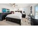 Bedroom with a ceiling fan, sleek black furniture, and natural light with water views at 213 Harrison Ave, Belleair Beach, FL 33786