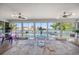 Bright dining room with water views through expansive windows and sleek, modern furnishings at 213 Harrison Ave, Belleair Beach, FL 33786