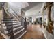 Elegant entryway features beautiful wood floors, a staircase with decorative iron railings, and views into the open living spaces at 213 Harrison Ave, Belleair Beach, FL 33786