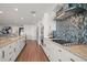 Modern kitchen with white cabinetry, granite countertops, blue tile backsplash, and stainless steel appliances at 213 Harrison Ave, Belleair Beach, FL 33786