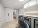 Well-lit laundry room features a modern washer, storage cabinets and access to other parts of the house at 213 Harrison Ave, Belleair Beach, FL 33786