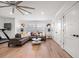 Bright living room featuring hardwood floors, a gray sectional sofa, and stylish decorative globe lighting fixtures at 213 Harrison Ave, Belleair Beach, FL 33786