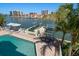 Waterfront home featuring a private pool, boat lift, and patio area with dining at 213 Harrison Ave, Belleair Beach, FL 33786