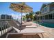 Inviting waterfront pool with lounge chairs and an umbrella for shaded relaxation at 213 Harrison Ave, Belleair Beach, FL 33786