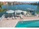 Luxury waterfront home featuring a private dock, boat lift, and a beautiful pool with lounge chairs and striped umbrellas at 213 Harrison Ave, Belleair Beach, FL 33786