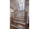 Staircase features beautiful wood and white risers, decorative iron railings, and accent wallpaper at 213 Harrison Ave, Belleair Beach, FL 33786