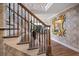 Staircase with wood and iron detailing, leading to a bright interior with statement mirror at 213 Harrison Ave, Belleair Beach, FL 33786
