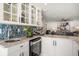 Wet bar featuring a wine fridge, glass-front cabinets, and countertop seating at 213 Harrison Ave, Belleair Beach, FL 33786