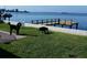 Grassy backyard by the bay with dock and two dogs at 2172 Harbor View Dr, Dunedin, FL 34698
