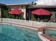 Inviting swimming pool and spa with red umbrellas offering shade at 2172 Harbor View Dr, Dunedin, FL 34698