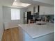 Bright kitchen with white cabinets, hardwood floors, stainless steel appliances, and a white countertop at 224 Cypress Ln # 224, Oldsmar, FL 34677