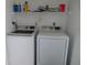 Efficient laundry area with modern washer and dryer, and overhead storage shelving at 224 Cypress Ln # 224, Oldsmar, FL 34677