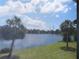 Relaxing water view from the back porch of a condo, featuring a serene lake and palm trees at 224 Cypress Ln # 224, Oldsmar, FL 34677