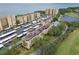 Aerial view of condo complex with parking, lush trees, and waterfront access at 2614 Cove Cay Dr # 207, Clearwater, FL 33760