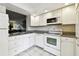 Efficient kitchen layout with granite countertops, updated appliances, and white cabinetry at 2614 Cove Cay Dr # 207, Clearwater, FL 33760
