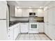 Bright kitchen with white appliances, ample cabinets, and granite countertops at 2614 Cove Cay Dr # 207, Clearwater, FL 33760