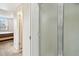 Bathroom view of the glass-door shower stall and an open door with view into the bedroom at 2614 Cove Cay Dr # 207, Clearwater, FL 33760