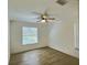 Bright bedroom with a ceiling fan, wood-look floor, and a large window at 2869 Thistle N Ct, Palm Harbor, FL 34684
