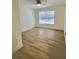 A bright, empty room with wood floors, white walls and a ceiling fan at 2869 Thistle N Ct, Palm Harbor, FL 34684