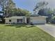 Well-manicured front yard of a single-story home featuring an attached two-car garage at 2869 Thistle N Ct, Palm Harbor, FL 34684