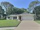Charming single-story home with a well-manicured lawn, mature trees, and a two-car garage at 2869 Thistle N Ct, Palm Harbor, FL 34684