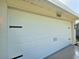 Close up of white two-car garage door with modern black hardware at 2869 Thistle N Ct, Palm Harbor, FL 34684