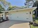 Front exterior view of home featuring a two-car garage with new garage door at 2869 Thistle N Ct, Palm Harbor, FL 34684