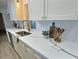Close up of a well-appointed counter featuring quartz countertops, a stainless steel sink, and modern fixtures at 2869 Thistle N Ct, Palm Harbor, FL 34684